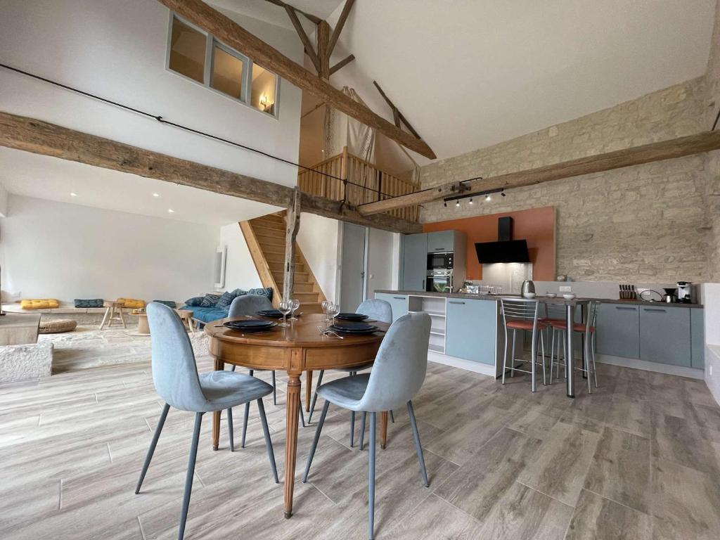 een keuken en eetkamer met een houten tafel en stoelen bij Maison Dompierre-sur-Mer, 2 pièces, 4 personnes - FR-1-246-603 in Dompierre-sur-Mer