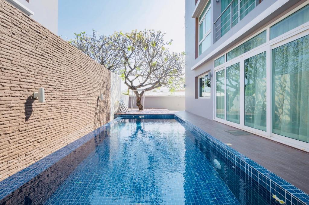 a swimming pool in a house with a brick wall at Luxury Pool Villa at Golden Sea Hua Hin in Hua Hin