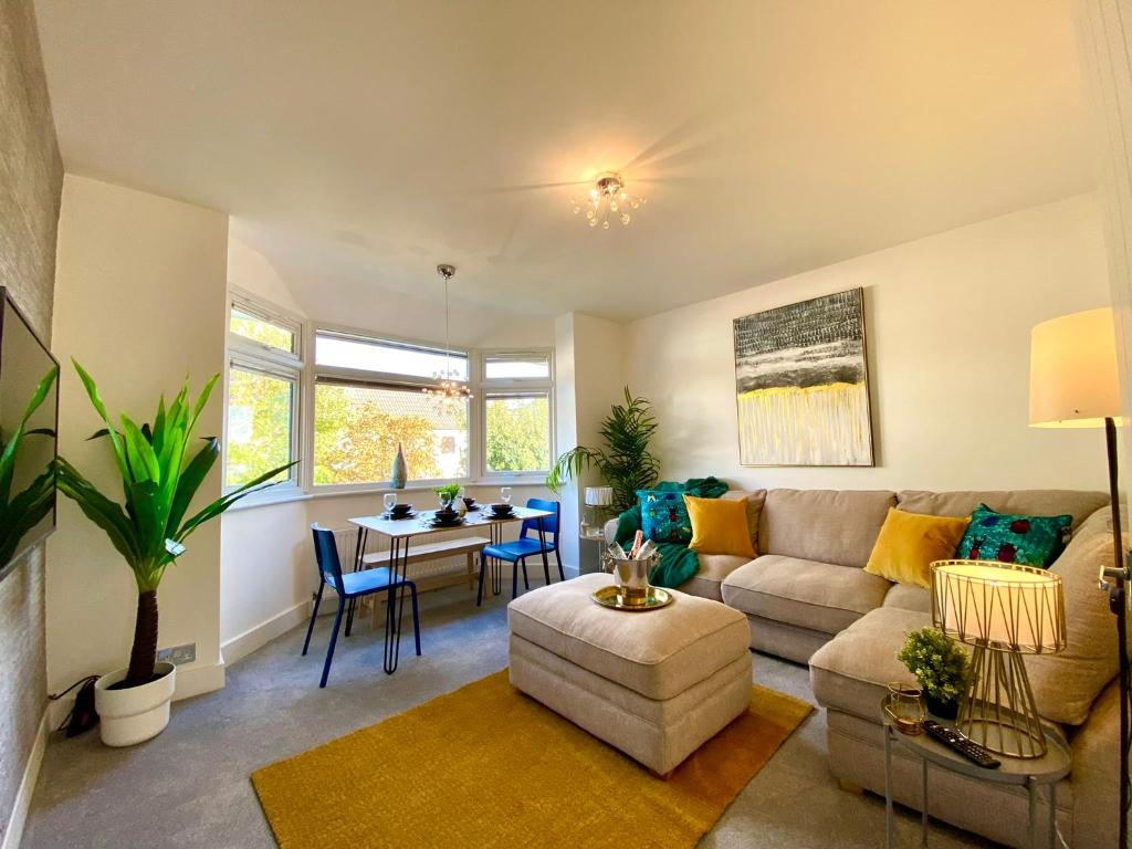 a living room with a couch and a table at 2 Min Walk to the Best Beach! Stunning Newly Refurbished Stylish 2 Bedroom Apartment! - Great Location - FREE Parking - Fast WiFi - Smart TV - sleeps up to 4! Close to Bournemouth & Poole Town Centre & Sandbanks in Bournemouth