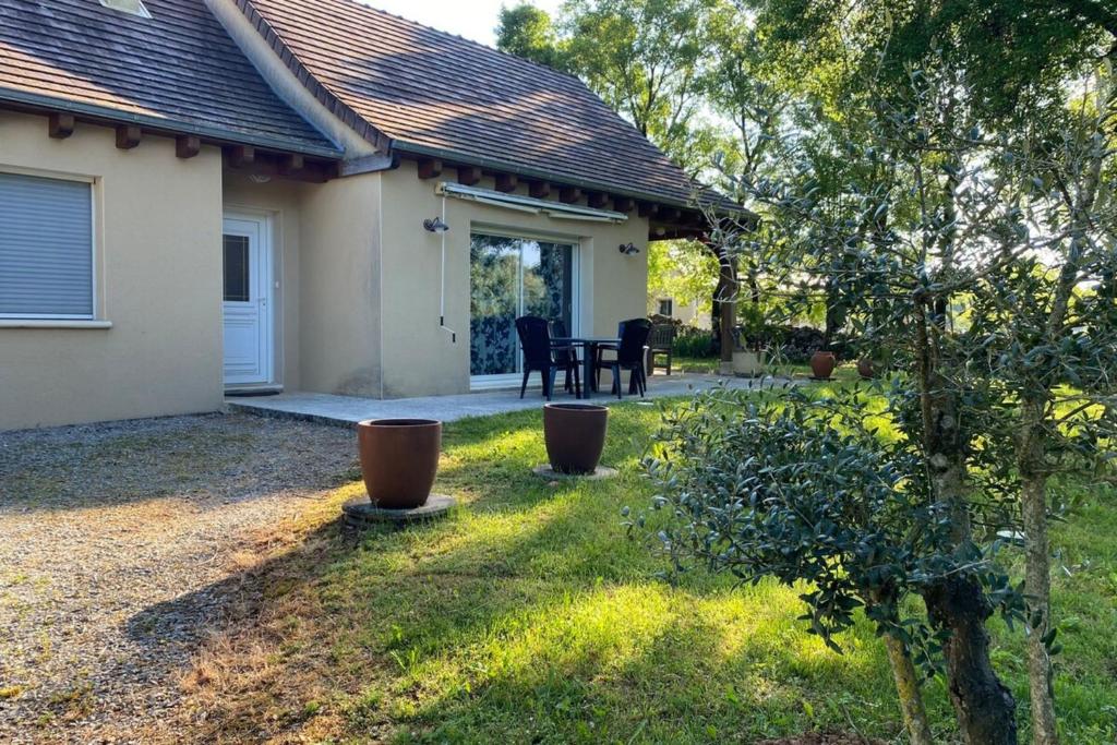 ein Haus mit einem Garten mit einem Tisch und Stühlen in der Unterkunft Maison de vacances à Gramat in Gramat