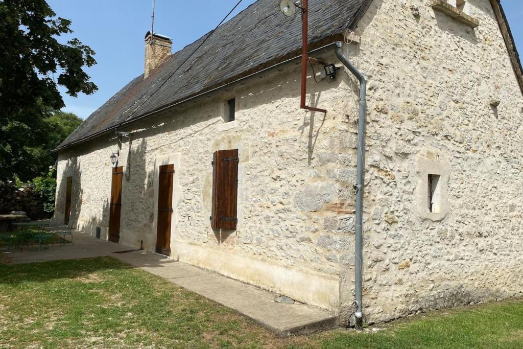 - un ancien bâtiment en pierre avec des portes marron dans l'établissement Gîte à Rocamadour, à Rocamadour