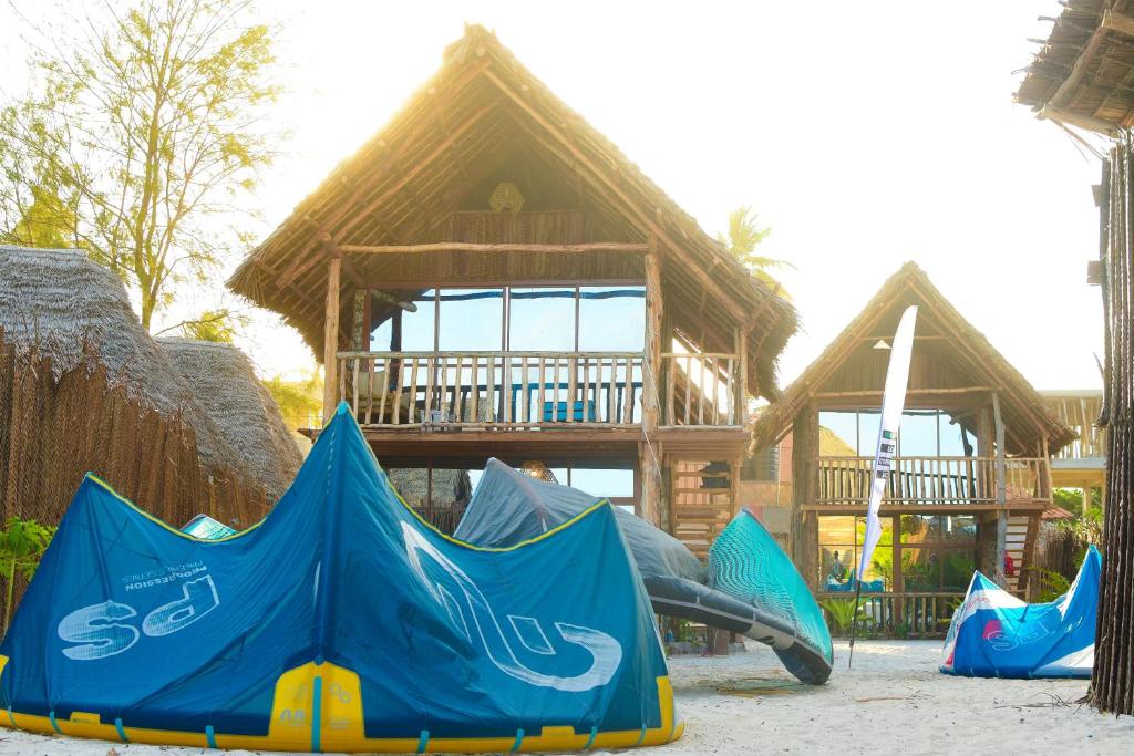 a playground in front of a wooden house with a tent at Mwananchi Bungalows in Paje