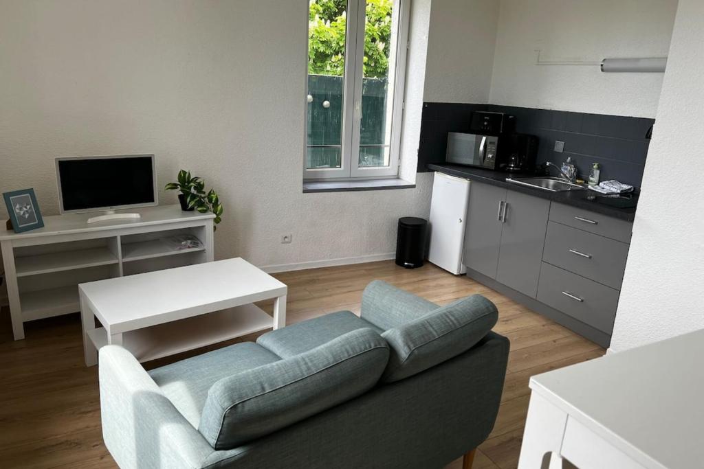 a living room with a couch and a kitchen at Gramat appartement centre ville in Gramat