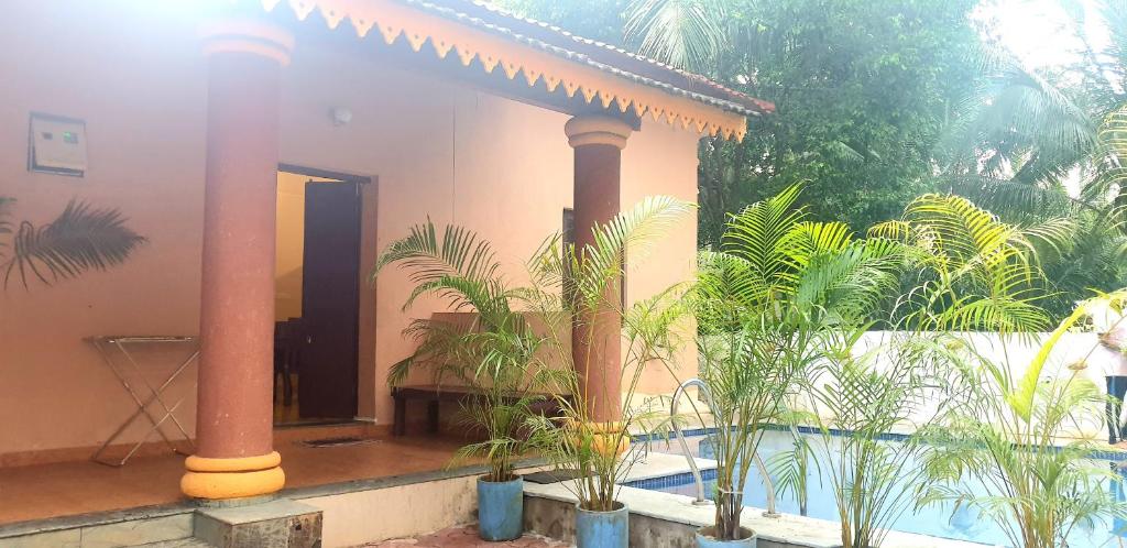 a house with two columns and a swimming pool at HERITAGE 7BHK VILLA WITH PRIVATE POOL close to BAGA BEACH in Parra