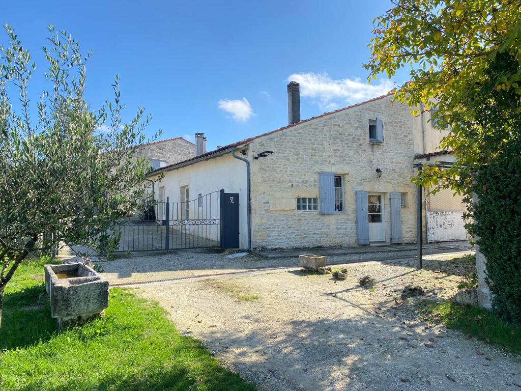 un ancien bâtiment en briques blanches avec une porte noire dans l'établissement Domaine de la Laigne - Spa, à Asnières-la-Giraud