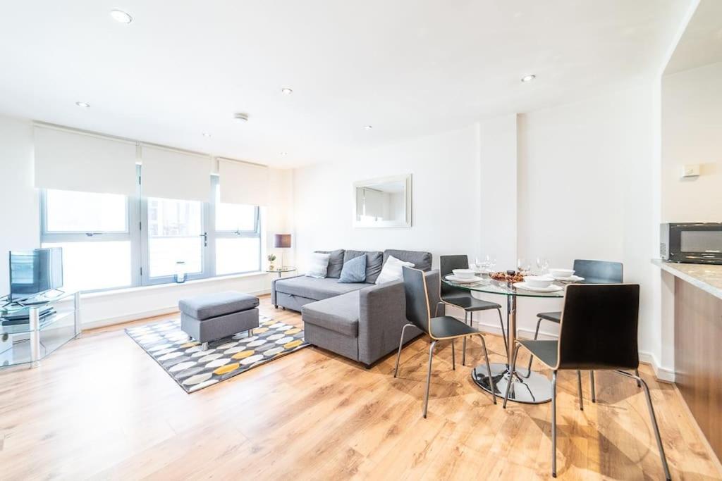 a living room with a couch and a table at Liverpool St Shoreditch London Terrace Apartment in London