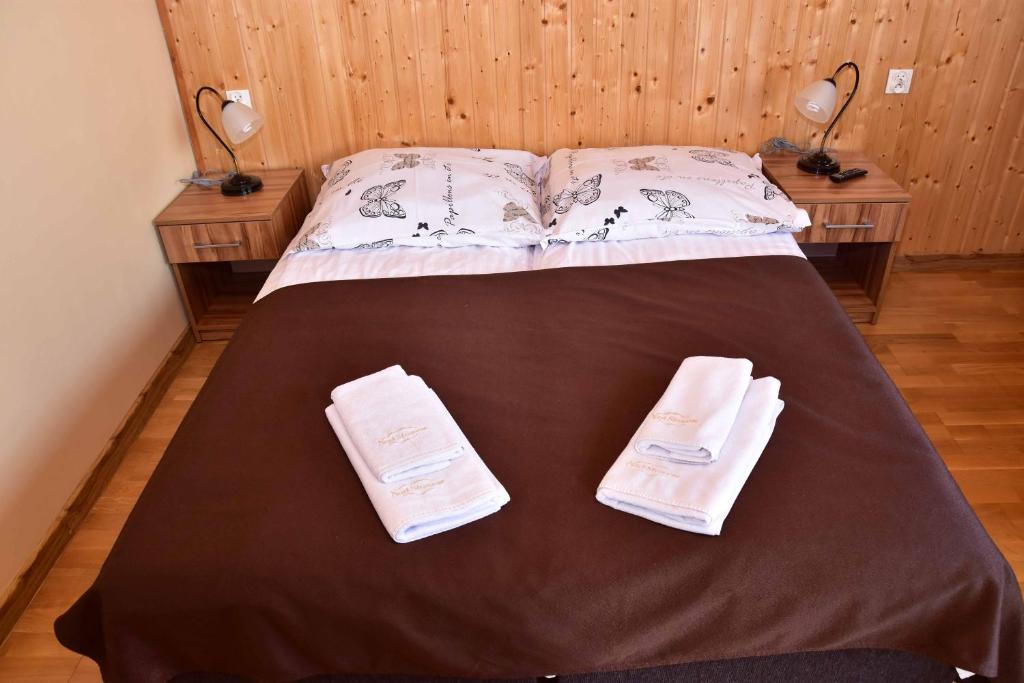 Una cama con dos toallas encima. en Nad Stawem, en Powidz