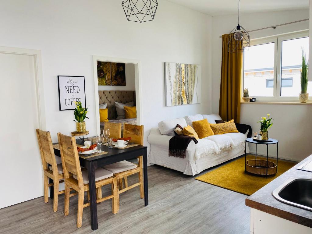 ein Wohnzimmer mit einem weißen Sofa und einem Tisch in der Unterkunft Aurum Apartment in Kirchheim am Neckar