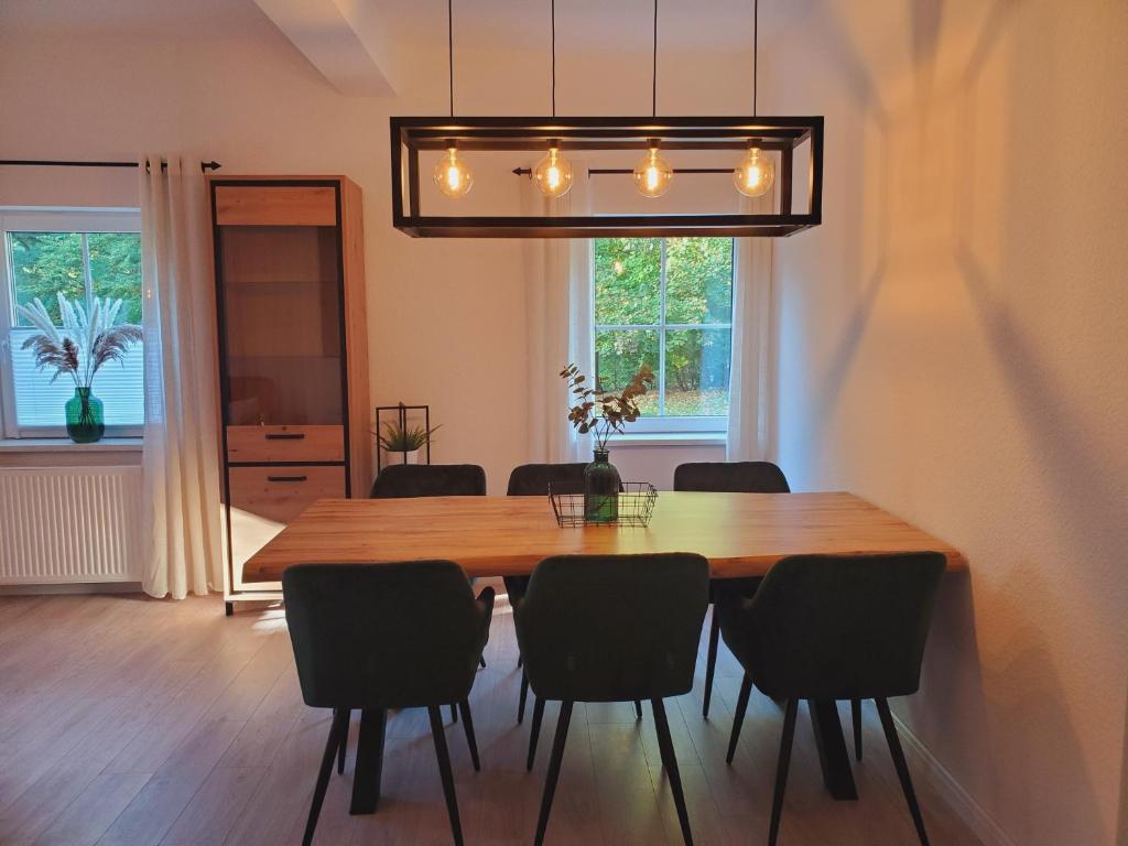 Familienfreundliche Ferienwohnung Soltau في سولتو: غرفة طعام مع طاولة وكراسي خشبية