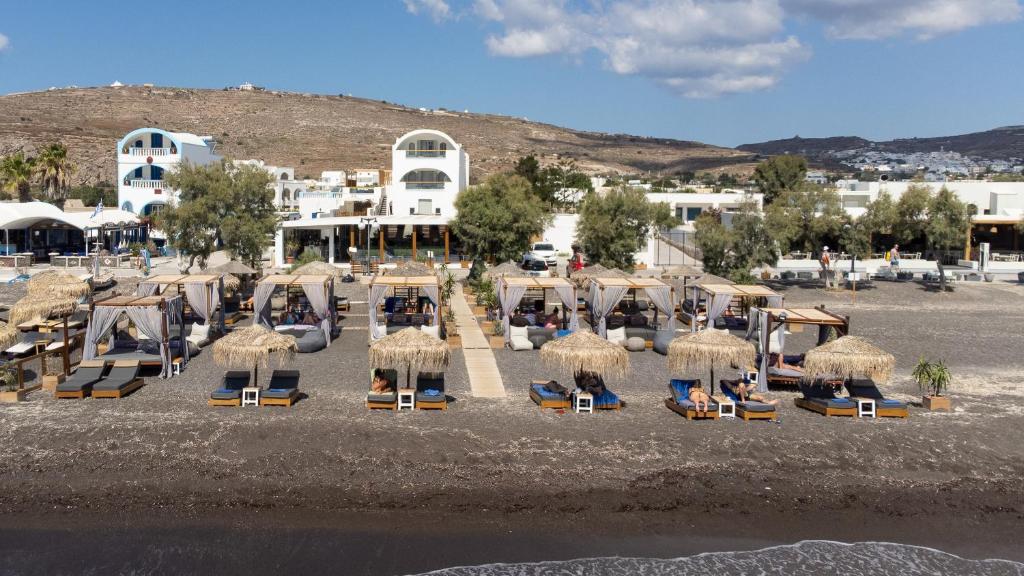 eine Gruppe von Stühlen und Sonnenschirmen am Strand in der Unterkunft Glykeria Mini Suites in Perivolos