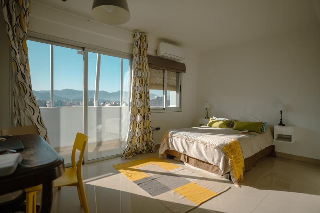 - une chambre avec un lit et une grande fenêtre dans l'établissement Departamento con vista a las montañas + garage, à Salta