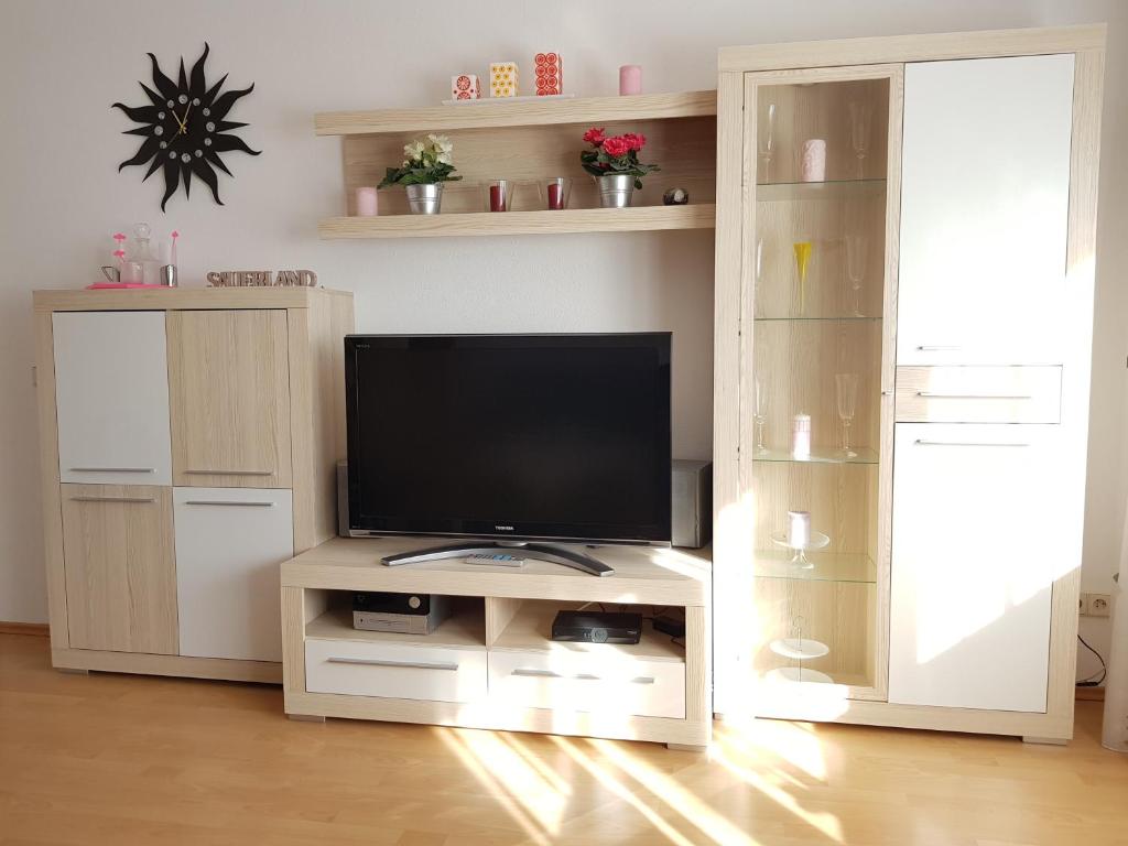 una sala de estar con TV en un centro de entretenimiento blanco en Ferienwohnung Jansen, en Kirchhundem