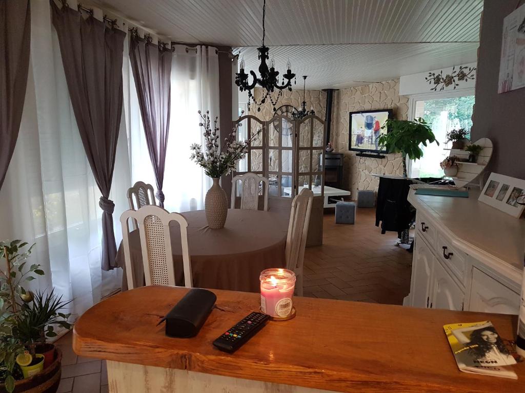 eine Küche und ein Esszimmer mit einem Tisch und einer Kerze darauf in der Unterkunft Chambres chez particuler proche du circuit in Ruaudin