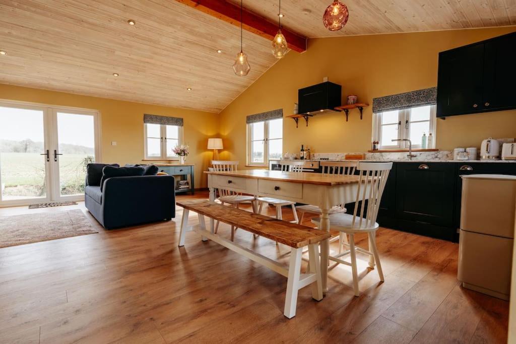 a kitchen and living room with a table and a couch at Beautiful Cottage in Bredfield near to Woodbridge on the Suffolk Coast in Bredfield