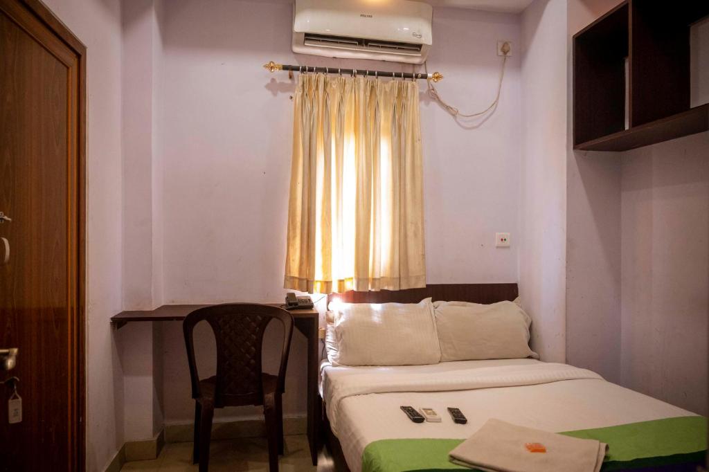 a small room with a bed and a desk and a window at Hotel City View INN in Guwahati