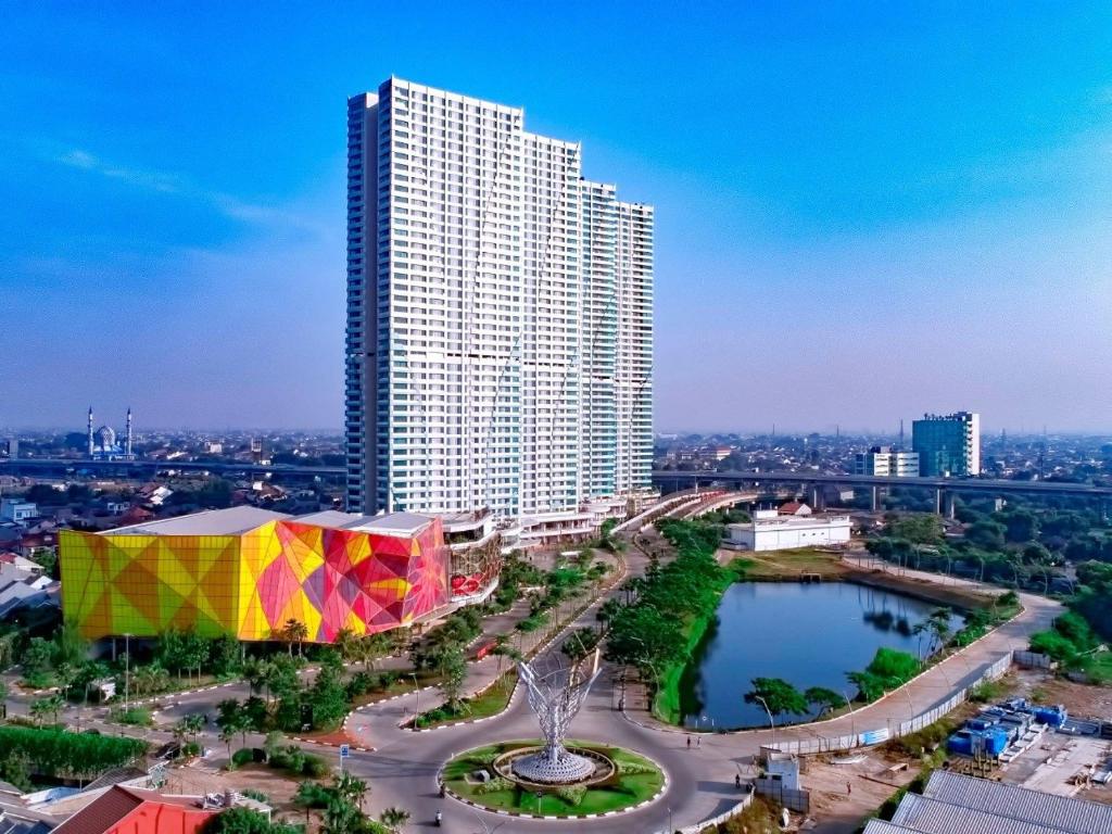 un grand bâtiment avec une tente colorée dans une ville dans l'établissement Grand Kamala Lagoon by 21 Room Netflix, à Bekasi