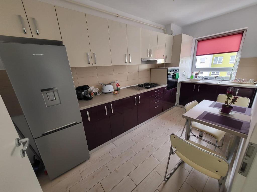 eine Küche mit einem Kühlschrank sowie einem Tisch und Stühlen in der Unterkunft Casa Brianna in Braşov