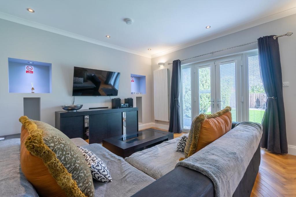 uma sala de estar com um sofá e uma televisão em Craigey Beach Home em Edinburgo