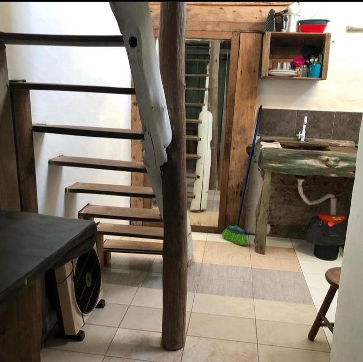 een houten trap in een kamer met een tafel bij Apartamentos completos a metros del mar in Aguas Dulces