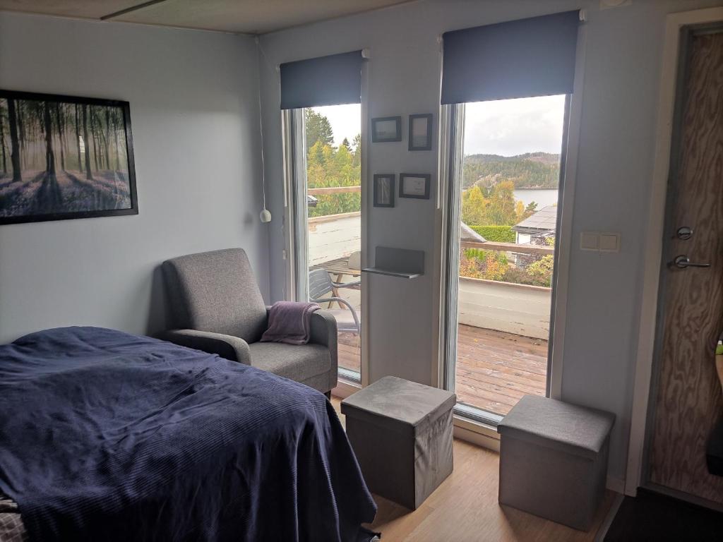 a bedroom with a bed and a chair and a window at Linus och Lottas Frigga in Hällingsjö