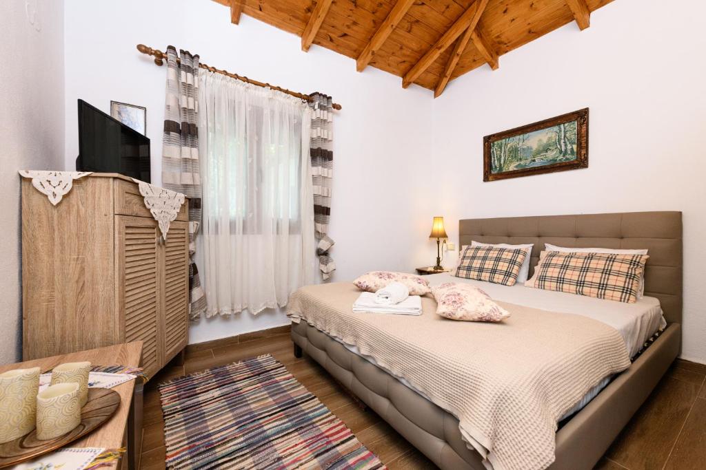 a bedroom with a bed and a flat screen tv at Villa Suzana in Mikros Prinos