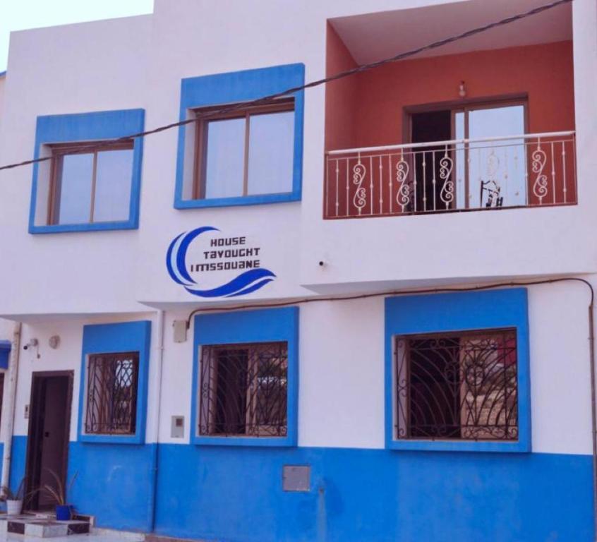 un edificio bianco e blu con balcone di House Tayought Imsouane a Imsouane