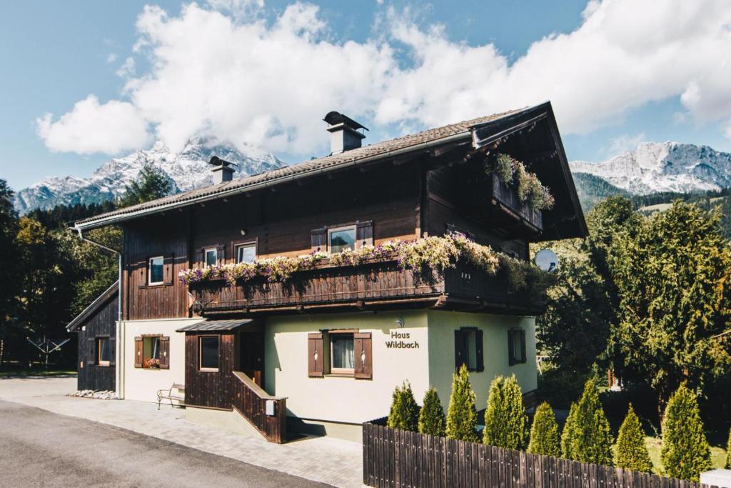 drewniany dom z górami w tle w obiekcie Haus Wildbach - Baranek Resorts w mieście Leogang