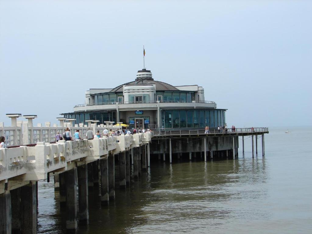 a pier with a large building on the water at luxurious apartment with sea view in Blankenberge