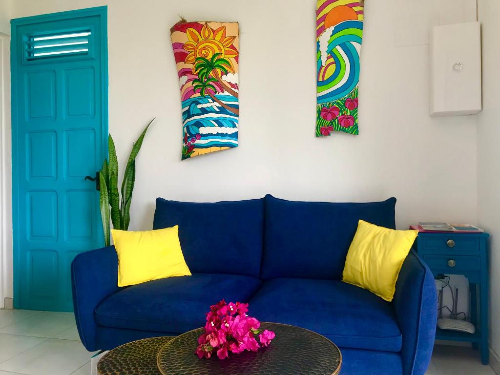 a blue couch in a living room with a table at appartement privé ECO-RESPONSABLE, magnifique vue sur la mer des Caraibes et jardin clos, WiFi, à 2mn de la plage in Sainte-Luce