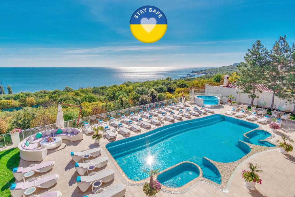 una foto della piscina della villa soriana con sedie a sdraio di Hotel Panorama De Luxe a Odessa
