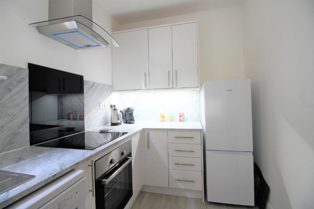 een keuken met witte kasten en een witte koelkast bij Keepers Rest Scarborough North Bay in Scarborough