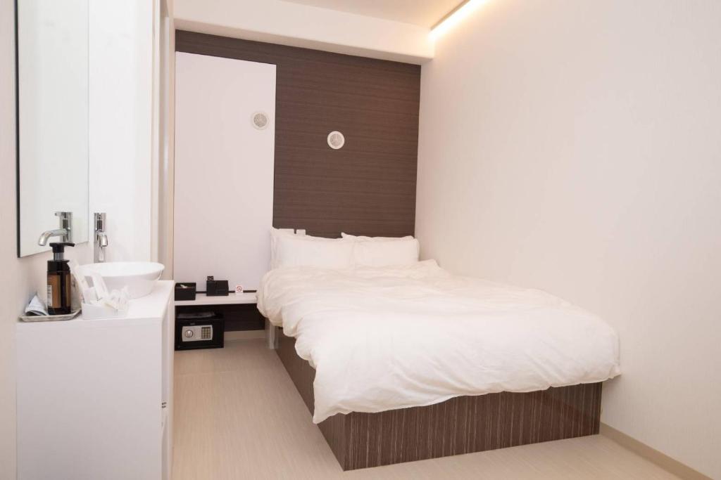 - une chambre avec un grand lit et un lavabo dans l'établissement Mutsumi Building - Vacation STAY 00543v, à Tokyo