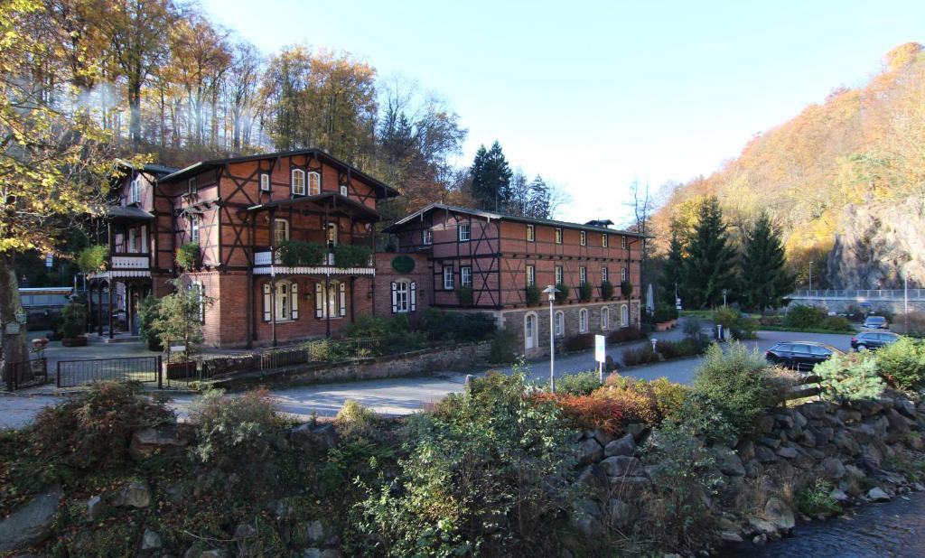 a large brick building in front of a mountain at Rabenauer Mühle "bed & breakfast" in Rabenau