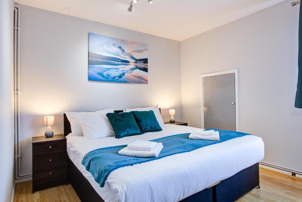 a bedroom with a large bed with two pillows on it at Statera Apartments - Studio Apartment in Walworth in London
