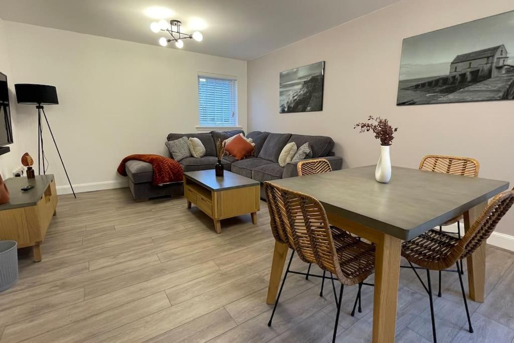 uma sala de estar com uma mesa e um sofá em Harbourside, Luxurious Elegant Holiday home with Bike store - Sleeps 6 em Wick