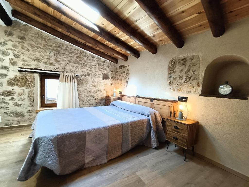 貝塞特的住宿－El Castellá，卧室配有一张石墙床