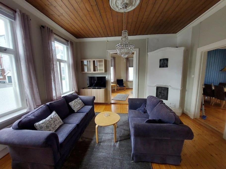 a living room with a blue couch and a table at Large, quiet and centrally located apartment in Fredrikstad