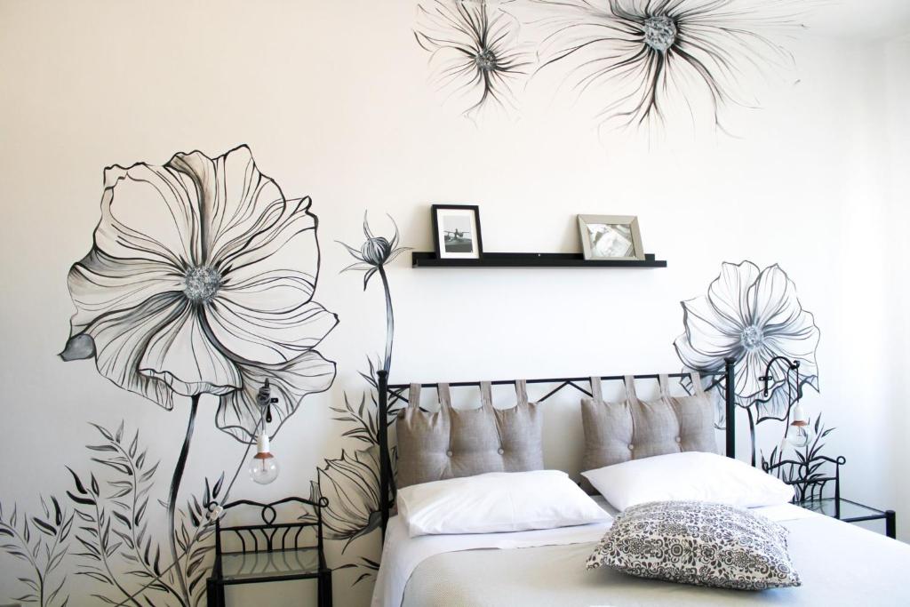 una camera da letto con un letto con fiori sul muro di Eufonia Vinyl Friendly Apartment a Roma