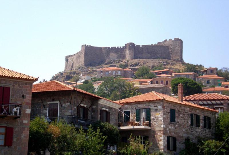 un château au sommet d'une colline avec des maisons dans l'établissement Stone House, à Mithimna