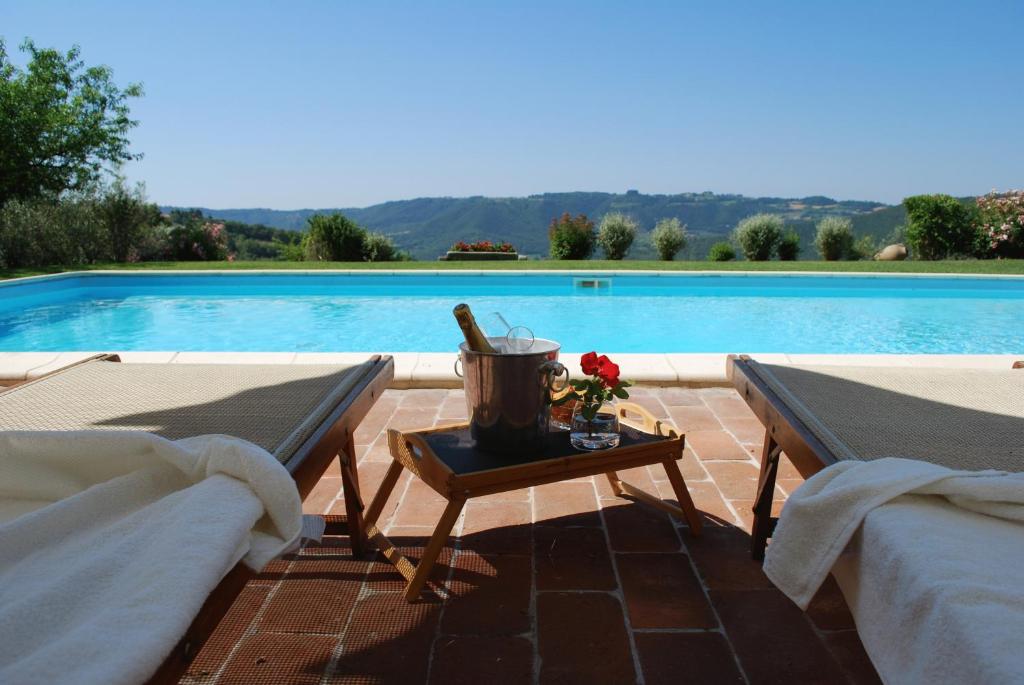 - une table avec un seau à côté de la piscine dans l'établissement Il Poggiolo di Parrano, à Parrano