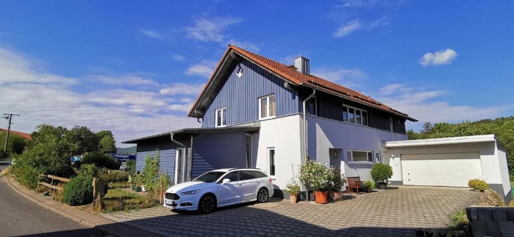 a white car parked in front of a house at Ferienwohnung Rhön Natur in Hilders