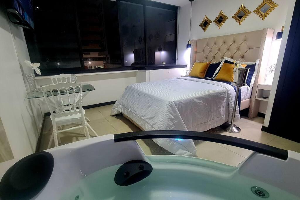 1 dormitorio con 1 cama y baño con bañera.  en Ecusuites Room Jacuzzi 105/2 Hidromasaje Privado, en Guayaquil