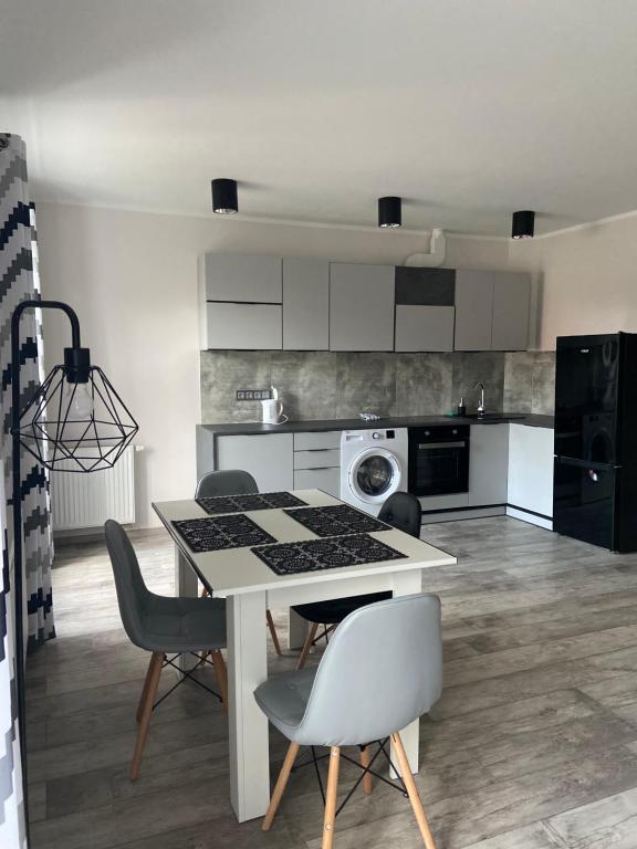 a kitchen with a table and chairs in a room at Apartamenty Bezrzecze in Szczecin