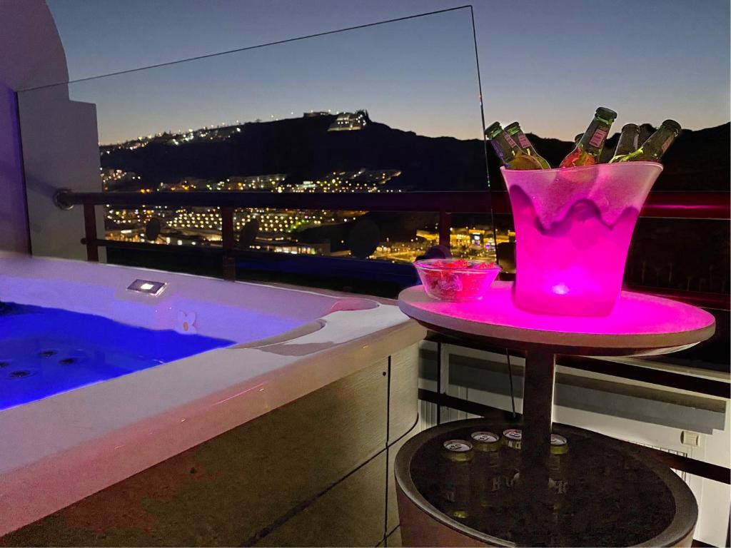 una mesa rosa con botellas de vino en el balcón en Villa Mogan Mall, con jacuzzi y PlayStation 5, en Puerto Rico de Gran Canaria