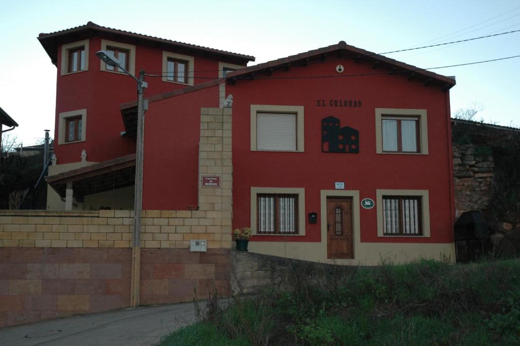 a red house with a sign on the side of it at Casa Rural El Colorao in Sotés