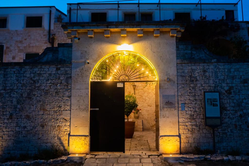 un accès à un bâtiment avec une porte et des lumières dans l'établissement Masseria Montepaolo Dimora di Charme, à Conversano
