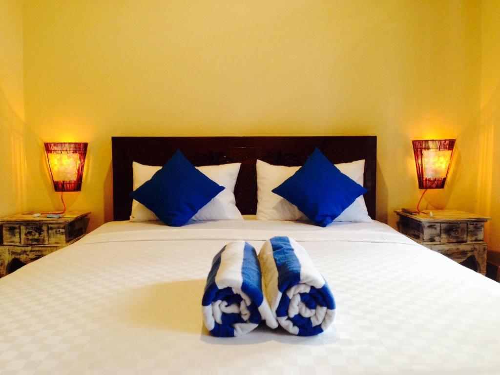 a bedroom with a bed with blue and white pillows at Chillin Kuta Homestay in Kuta