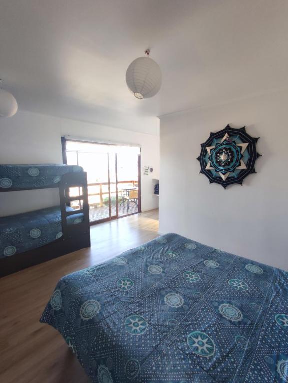 a bedroom with a bed and a clock on the wall at La Tribu Ecolodge y Camping in Algarrobo