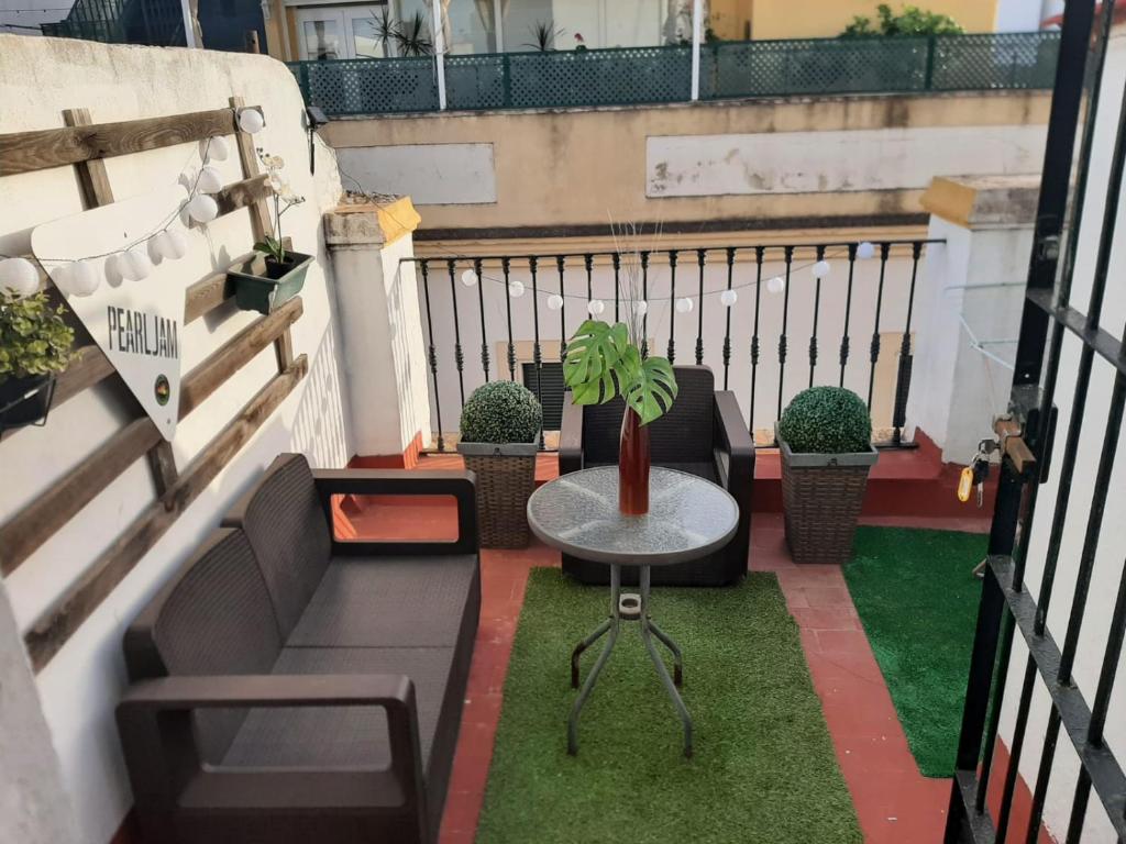 eine Terrasse mit einem Sofa und einem Tisch auf dem Balkon in der Unterkunft Ático en el Corazón de Sevilla in Sevilla