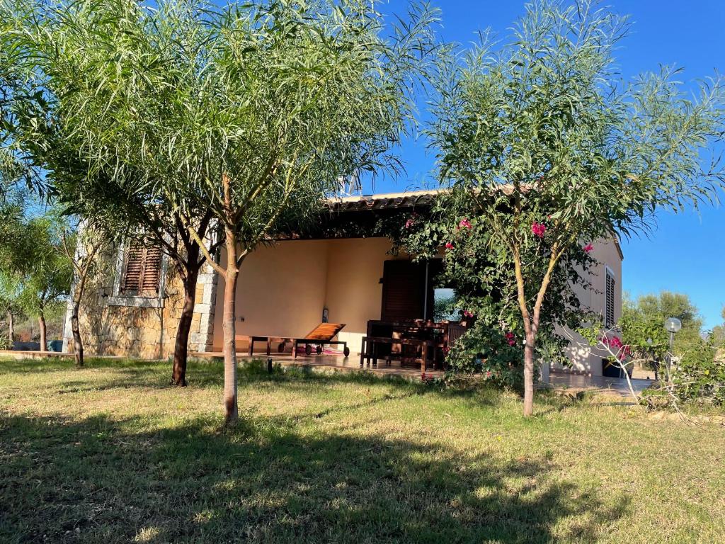 una casa con una mesa de picnic y dos árboles en Domo Sara, en Orosei
